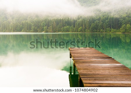 Jetty at lake Walchensee in the Alps of Bavaria on a misty morning in summer