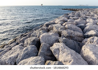 Jetty Made Of Large Stones And Rocks Extending Into The Sea On Bluewaters Island In Dubai. Parasailing Wing In The Background. 