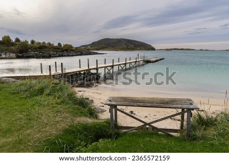 Jetty on the Atlantic near Sommarøy, Norway. Sandy beach with barbecue area and relaxation area, by the turquoise sea, surrounded by flowers and bushes. like in the Caribbean!