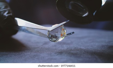 Jeweler Examining Big Translucent Diamond Using Silver Tweezers And Black Latex Gloves To Verify If It Is Authentic Or Fake