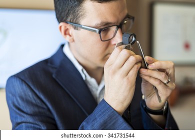 Jeweler examining diamond thoroughly through loupe