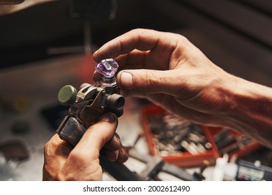 Jeweler is inserting amethyst into gem-cutting tool