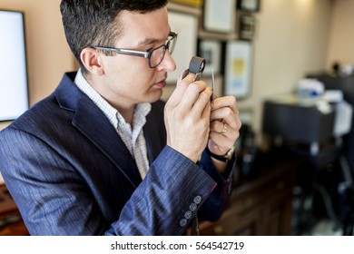 Jeweler Looking At Diamond Through Loupe To Inspect It