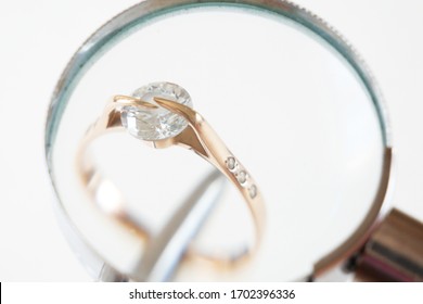 jeweler looking at jewelry through magnifying glass, jewerly inspect and verify, wedding ring in pawnshop