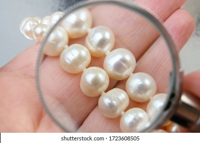 jeweler looking at pearls necklace through magnifying glass, jewerly inspect and verify, pawnshop concept, jewerly shop concept