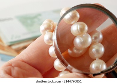 jeweler looking at pearls necklace through magnifying glass on black background, jewerly inspect and verify, pawnshop concept, jewerly shop concept