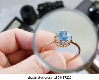 jeweler looking at ring with blue stone, jewerly inspect and verify, pawnshop concept, jewerly shop, closeup