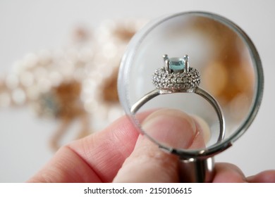 jeweler looking at ring with blue stone, jewerly inspect and verify, pawnshop concept, jewerly shop, closeup - Shutterstock ID 2150106615