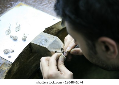 Jeweler making handmade jewelry on vintage bench. The art of jewelry.