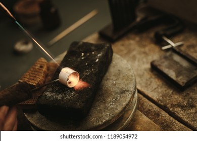 Jeweler solders and welds metal ring at workstation. Jewelry making  a ring at workshop. - Powered by Shutterstock