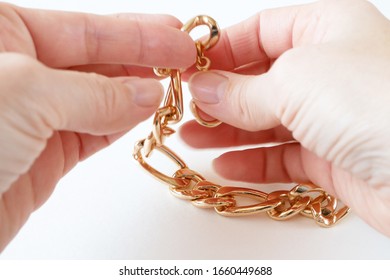 Jeweler Takes In Hands The Big Gold Chain On White Background, Jewerly Inspect And Verify	