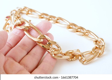 Jeweler Takes In Hands The Big Gold Chain On White Background, Jewerly Inspect And Verify	