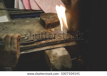 Jeweler using tools to create a ring