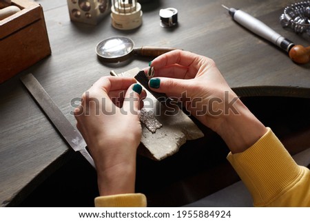 Jeweler At Work In Jewelery Workshop. Desktop for craft jewellery making with professional tools. Vintage jeweler tools on wooden table. Jewelry craftsmanship