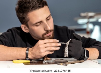 A jeweler in the workshop working on a bracelet. Close-up of a bracelet in the hands of a jeweler