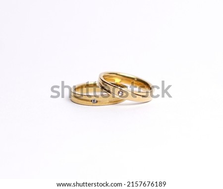 Jewelery ring with diamonds. Wedding rings that have deep meaning and significance. Engagement ring with gemstones. Wedding ring isolated on white background, focus blur. Pair in gold, silver, black.
