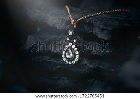 Jewelery standing on black rock concept - diamond necklace