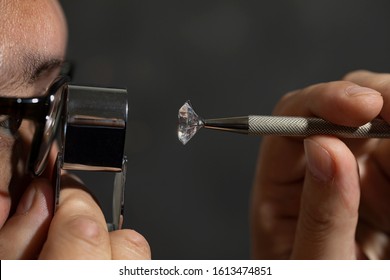 Jeweller buyer checking polished diamond in jewellery exhibition. Polished diamond grading. Jewellery and diamond trading.