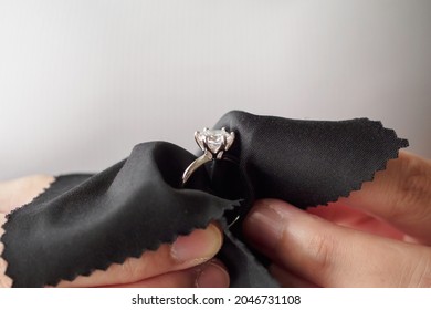 Jeweller cleaning jewelry diamond ring with fabric cloth - Powered by Shutterstock