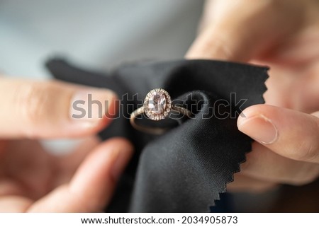 Jeweller cleaning jewelry diamond ring with fabric cloth