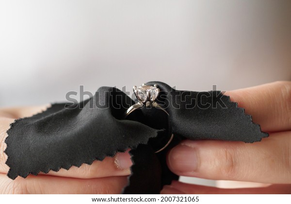 Jeweller\
cleaning jewelry diamond ring with fabric\
cloth