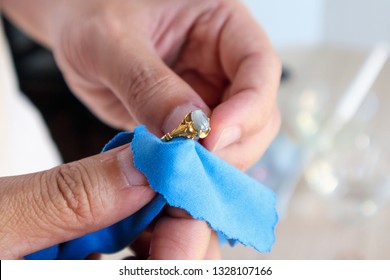 Jeweller Hand Polishing And Cleaning Gold Jewelry Ring With Micro Fiber Fabric