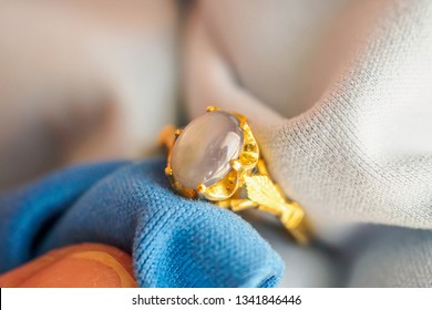 Jeweller Hand Polishing And Cleaning Gold Jewelry Ring With Micro Fiber Fabric