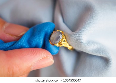 Jeweller Hand Polishing And Cleaning Gold Jewelry Ring With Micro Fiber Fabric