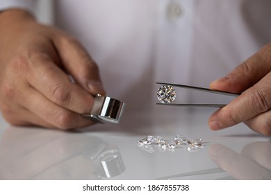 Jeweller with nice diamond at work. Retail store shopping. Grading expert holding brilliant in gemmology lab.