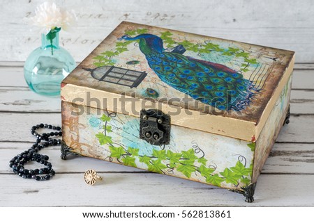 A jewellery box decoupaged with a Peacock and gilded with gold leaf