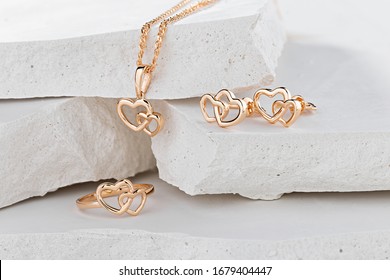 Jewellery set of hearts shape rose gold ring, pendant necklace and stud earrings on white background. Romantic  jewelry. Advertising still life product concept for Valentines Day - Shutterstock ID 1679404447