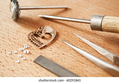 Jewellery tools and articles made of gold on the table.