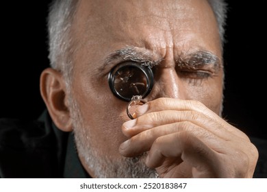 Jewelry appraiser examines a gold ring evaluating large diamond looking through magnifying glass monocular. Professional goldsmith identify gemstones, determine values luxury wedding engagement ring. - Powered by Shutterstock