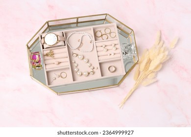 Jewelry box with many different accessories, perfumes and dry flowers on pink marble table, flat lay - Shutterstock ID 2364999927