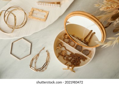 Jewelry Box With Mirror And Stylish Golden Bijouterie On White Marble Table, Flat Lay