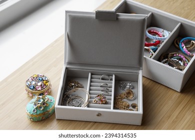 Jewelry boxes with many different accessories on wooden table - Shutterstock ID 2394314535