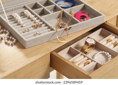 Jewelry boxes with many different accessories on wooden table, closeup