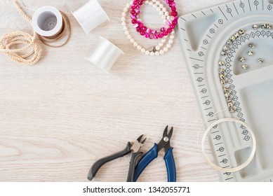 Jewelry designer workplace. Handmade, craft concept. Materials for making jewelry. Beading bracelets and necklaces settings. Freelance workspace in flat lay style