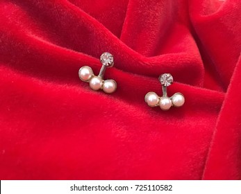 Jewelry Earrings With Pearl And Diamonds On Red Background. 