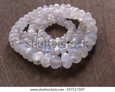 Jewelry from faceted mineral - moonstone on wooden background