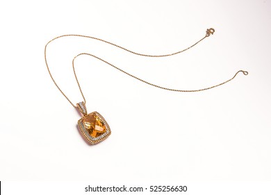Jewelry gold pendant with yellow diamond on the white background - Shutterstock ID 525256630