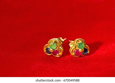 Jewelry Golden Earrings with Colorful Gems Isolated on Red Velvet. - Shutterstock ID 670549588