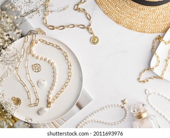 Diseño plano de estilo de vida de joyas con lugar para texto. Fondo de joyas. Mesa de mármol con magníficos y elegantes collares dorados y perlas, cadenas y elegantes colgantes. Accesorios de moda.