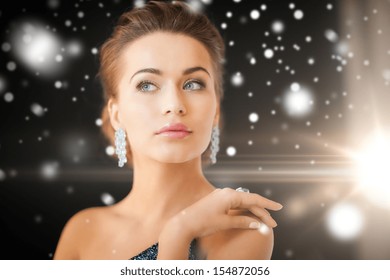 Jewelry, Luxury, Vip, Nightlife, Party Concept - Beautiful Woman In Evening Dress Wearing Diamond Earrings