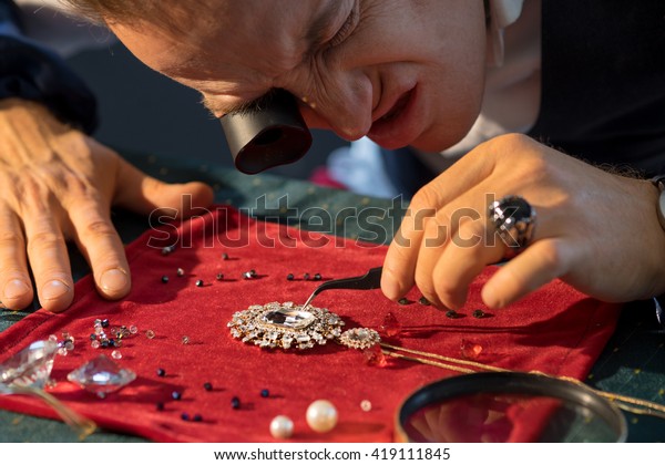 https://image.shutterstock.com/image-photo/jewelry-maker-considers-jewel-600w-419111845.jpg