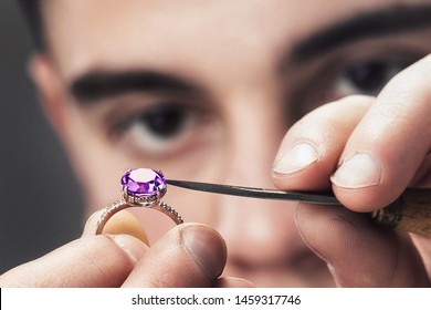 Jewelry master examines the gold ring for defects, close-up