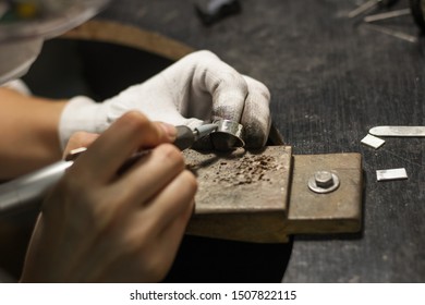 A jewelry master is working to create a silver ring.
Workshop location. Tools. Desktop. Hammers. Fire. - Powered by Shutterstock