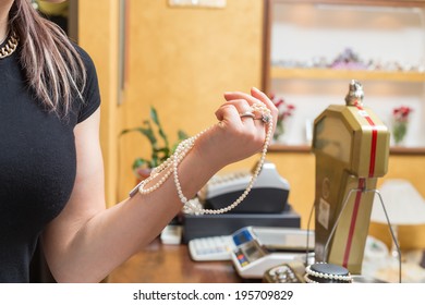 Jewelry Store Owner Shows Some Pearl Necklace