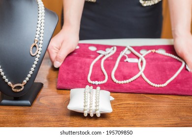 Jewelry Store Owner Shows Some Pearl Necklace And Bracelets