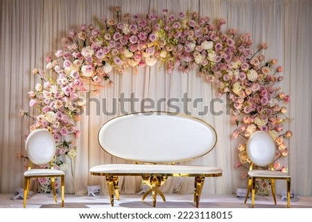 Jewish bride wedding chair, chuppah at wedding day ceremony. Flowers and  vases with chaise lounge.